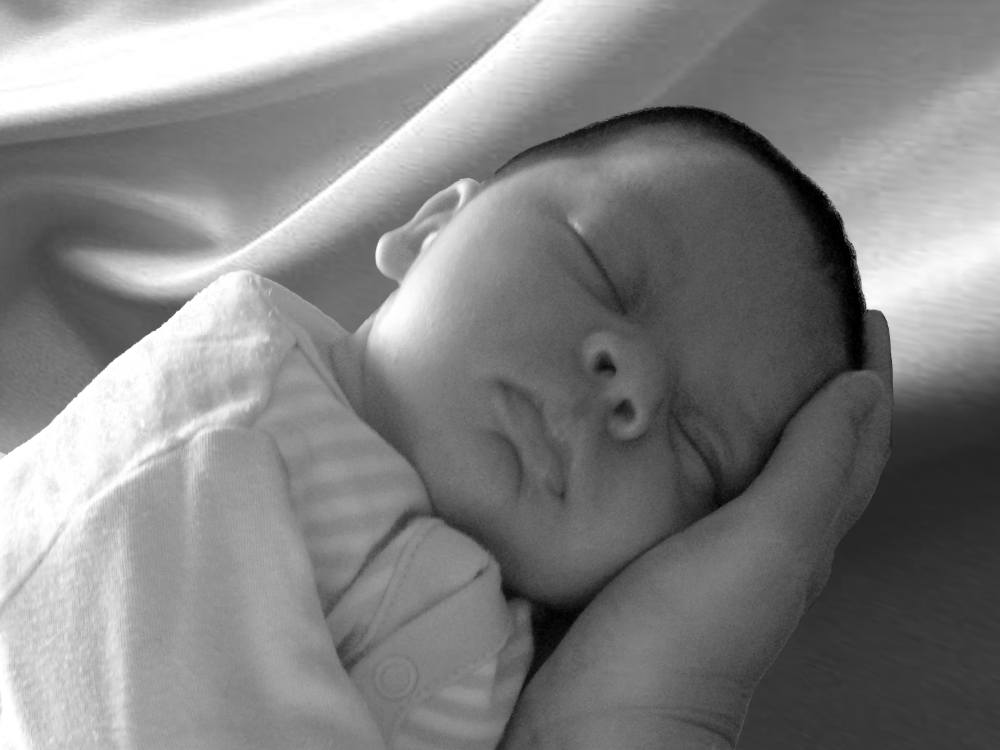 Image of sleeping baby receiving cranial treatment.